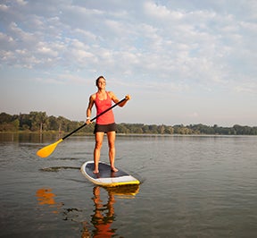 Woman paddle-boarding on a great lake.