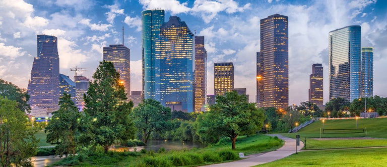 Houston skyline behind a lush green park.