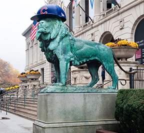 Chicago cubs lion statue with Chicago cub baseball hat.