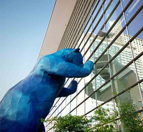 Denver's blue bear statue looking through the convention center windows.
