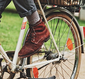 Man on a bicycle with luggage over the rear tire.
