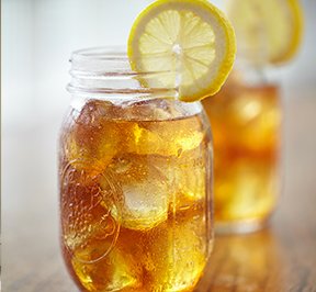 A glass of sweet tea sitting on a table.