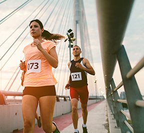 Boston marathon runners on a bridge.